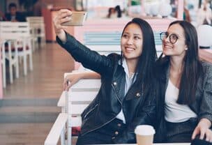 Hai người bạn chụp ảnh trong quán cà phê